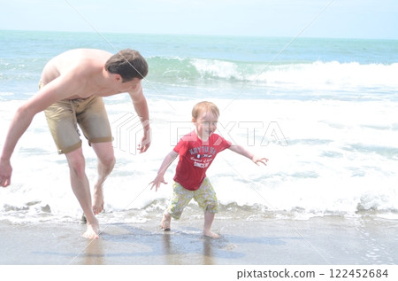 Dad and son playing on the shoreline. Summer enjoyment 122452684