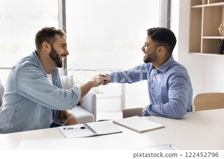 Two happy teammates giving fist bump gesture Two happy teammates giving fist bump gesture 122452796
