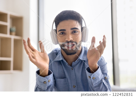 Man looks at camera, lead conversation using videoconference application, webcam 122452831