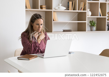 Serious mature employee working on laptop in boardroom Serious mature employee working on laptop in boardroom 122452875