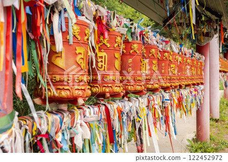 Rotating religious elements for touching turning spinning Buddhist prayer wheel at Buddhist monastery. Prayer wheels in Buddhist stupa temple. Buddhism religion concept 122452972