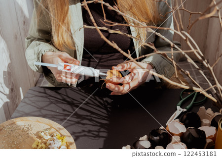 Unrecognizable woman creating Easter holiday decoration from egg shell. Diy do it yourself step by step instruction. Crafting preparation 122453181