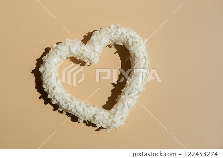 Symbol of love beautiful flower petals in heart shape in beige background. Creative concept of St Valentines day, weeding romantic date or anniversary. Copy space Symbol of love beautiful flower petals in heart shape in beige background. Creative concept of St Valentines day, weeding romantic date or anniversary. Copy space 122453274