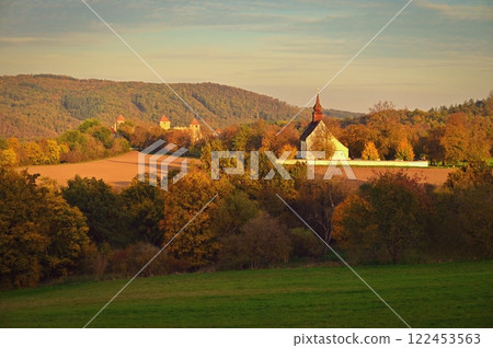 Beautiful autumn landscape with old Chapel of the Mother of God in Veveri. Sunset and beautiful blue sky with clouds. Colorful nature background on autumn season. Brno - Czech Republic. 122453563