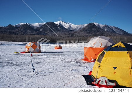 A view of the snowy mountains from a smelt fishing tent on the completely frozen Lake Nukabira 122454744