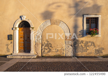 Facade of an old house in Lazise town on shore of Lake Garda at sunset, Italy, Europe. Facade of an old house in Lazise town on shore of Lake Garda at sunset, Italy, Europe. 122455490