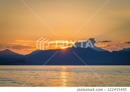 Lake Garda with mountains in background at sunset, view from Lazise town shore, Italy, Europe. 122455495