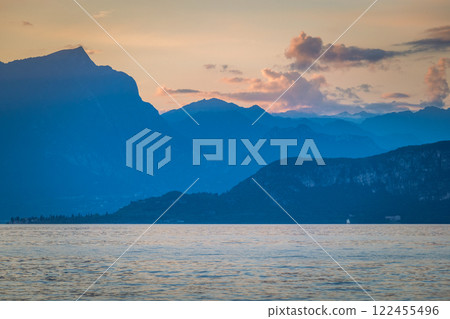 Lake Garda with mountains in background at sunset, view from Lazise town shore, Italy, Europe. 122455496