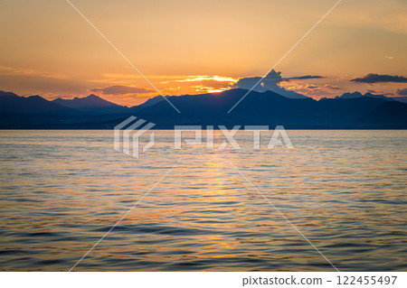 Lake Garda with mountains in background at sunset, view from Lazise town shore, Italy, Europe. 122455497