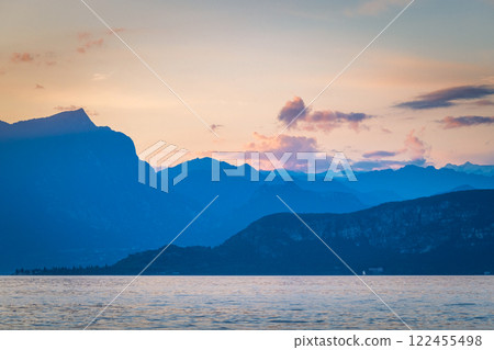 Lake Garda with mountains in background at sunset, view from Lazise town shore, Italy, Europe. Lake Garda with mountains in background at sunset, view from Lazise town shore, Italy, Europe. 122455498