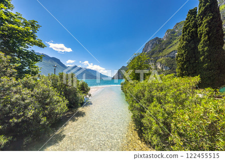 Lake Garda with mountains in background, view from Riva del Garda town shore, Italy, Europe. Lake Garda with mountains in background, view from Riva del Garda town shore, Italy, Europe. 122455515
