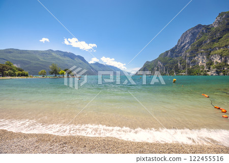 Lake Garda with mountains in background, view from beach in Riva del Garda town, Italy, Europe. Lake Garda with mountains in background, view from beach in Riva del Garda town, Italy, Europe. 122455516