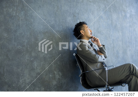 Man in suit sitting on chair Man in suit sitting on chair 122457207