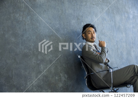 穿著西裝的男人坐在椅子上 穿著西裝的男人坐在椅子上 122457209
