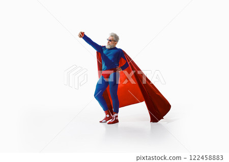 Funny grey-haired man in superhero costume and trendy sunglasses taking selfie with a kiss face against white studio background 122458883