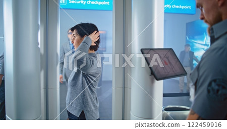 Adult Woman Walks Through Metal Detector Scanner for Boarding Plane Flight Adult Woman Walks Through Metal Detector Scanner for Boarding Plane Flight 122459916
