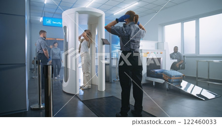 Woman Walks Through Metal Detector Gates. Security Officer Checks Passenger and Documents Woman Walks Through Metal Detector Gates. Security Officer Checks Passenger and Documents 122460033
