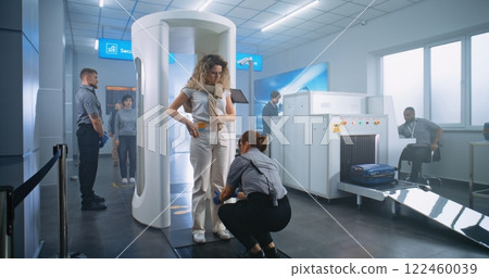 Woman Walks Through Metal Detector Gates. Security Officer Checks Passenger and Documents 122460039