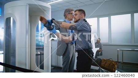 Businessman on Security Checkpoint in Airport Terminal: Security Officer Inspects Passenger 122460040