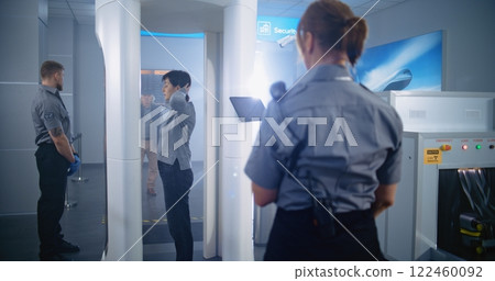 Woman Passes Through Metal Detector Scanner. Female Security Officer Checks Passenger, Ticket 122460092