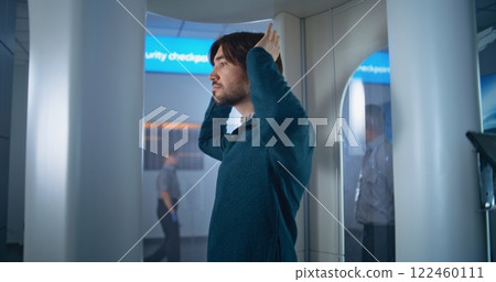International Airport Terminal: Adult Man Passes Through Metal Detector Gates on Security Checkpoint International Airport Terminal: Adult Man Passes Through Metal Detector Gates on Security Checkpoint 122460111