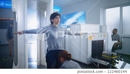 Woman Passes Through Metal Detector Scanner Gates. Female Security Officer Checks Passenger 122460144