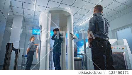 Diverse People Walking Through Metal Detector Scanner in Airport Terminal 122460171