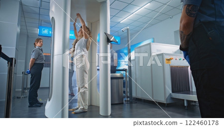 Diverse People Walking Through Metal Detector Scanner in Airport Terminal 122460178