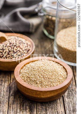 Mixed uncooked quinoa seeds in bowl on wooden table. Mixed uncooked quinoa seeds in bowl on wooden table. 122460367