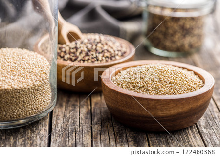 Mixed uncooked quinoa seeds in bowl on wooden table. 122460368