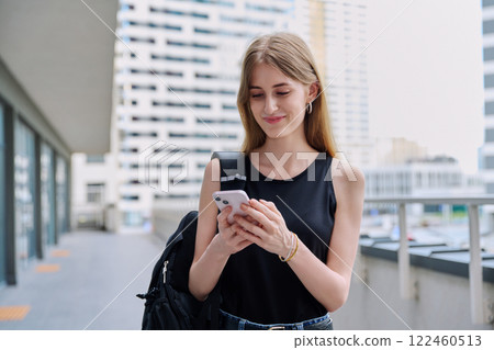 Young female using smartphone, modern city background Young female using smartphone, modern city background 122460513