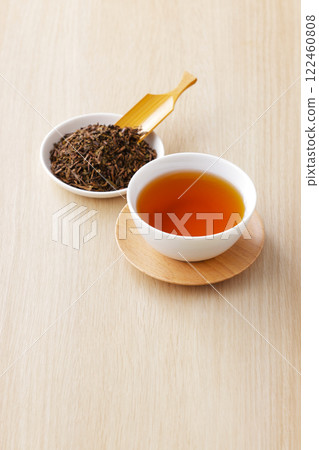 Hojicha tea poured into a teacup with tea leaves 122460808