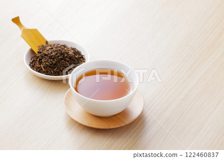 Hojicha tea poured into a teacup with tea leaves Hojicha tea poured into a teacup with tea leaves 122460837