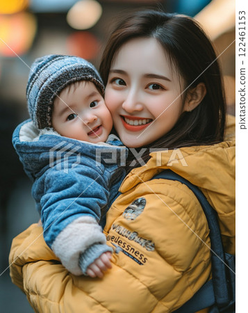 A warm moment between a smiling mother and baby in a winter town 122461153
