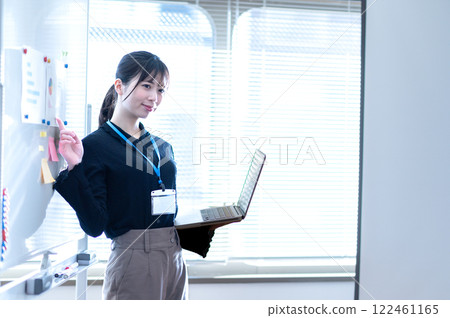 Young businesswoman giving a presentation using a whiteboard 122461165