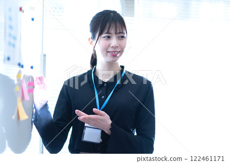 Young businesswoman giving a presentation using a whiteboard Young businesswoman giving a presentation using a whiteboard 122461171