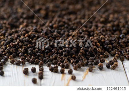 black pepper seeds on a white wooden table, selective focus. 122461915