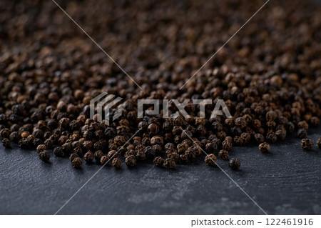black peppercorns on a black kitchen table, selective focus. black peppercorns on a black kitchen table, selective focus. 122461916