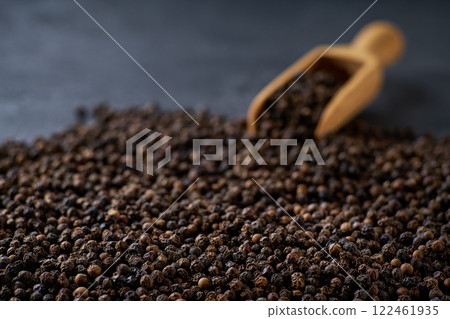 black pepper seeds on a black stone table, selective focus. 122461935