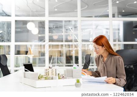 Female young architect working on a new sustainable construction project Female young architect working on a new sustainable construction project 122462034