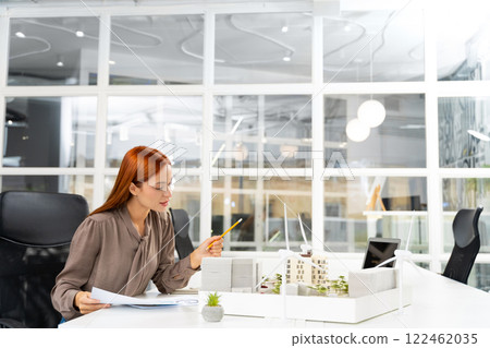 Female young architect working on a new sustainable construction project Female young architect working on a new sustainable construction project 122462035