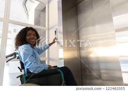 Female entrepreneur with disabilities in wheel chair waiting for elevator in office at work 122462055