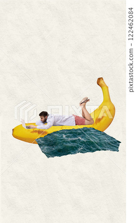 Surfing the internet. Businessman lying on giant banana floating in ocean, working on laptop. Digital lifestyle, work-life fusion 122462084