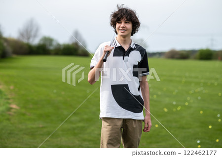 Young golfer standing on a gold cart and looking confident Young golfer standing on a gold cart and looking confident 122462177