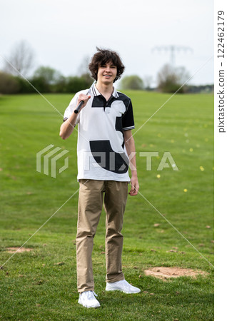Young golfer standing on a gold cart and looking confident Young golfer standing on a gold cart and looking confident 122462179