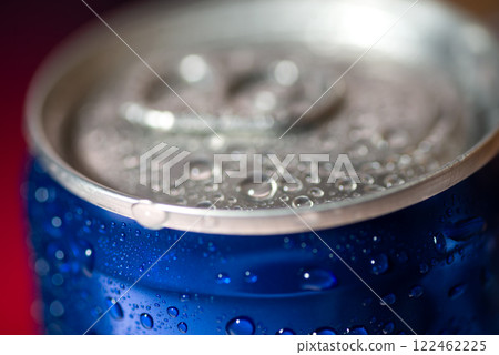 A tin can of cola and a blurry red and blue photo. The top of a tin can of cola A tin can of cola and a blurry red and blue photo. The top of a tin can of cola 122462225