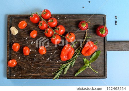 Fresh Tomatoes, Peppers, and Herbs on Wooden Board 122462234