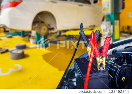 Car battery with jumper cables in auto repair shop Car battery with jumper cables in auto repair shop 122462844