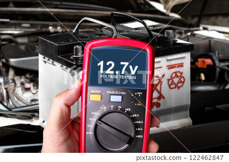 Car battery voltage testing , voltage testing with multimeter on car battery by mechanic 122462847