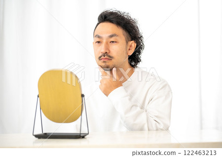 Japanese man checking his skin in the mirror 122463213